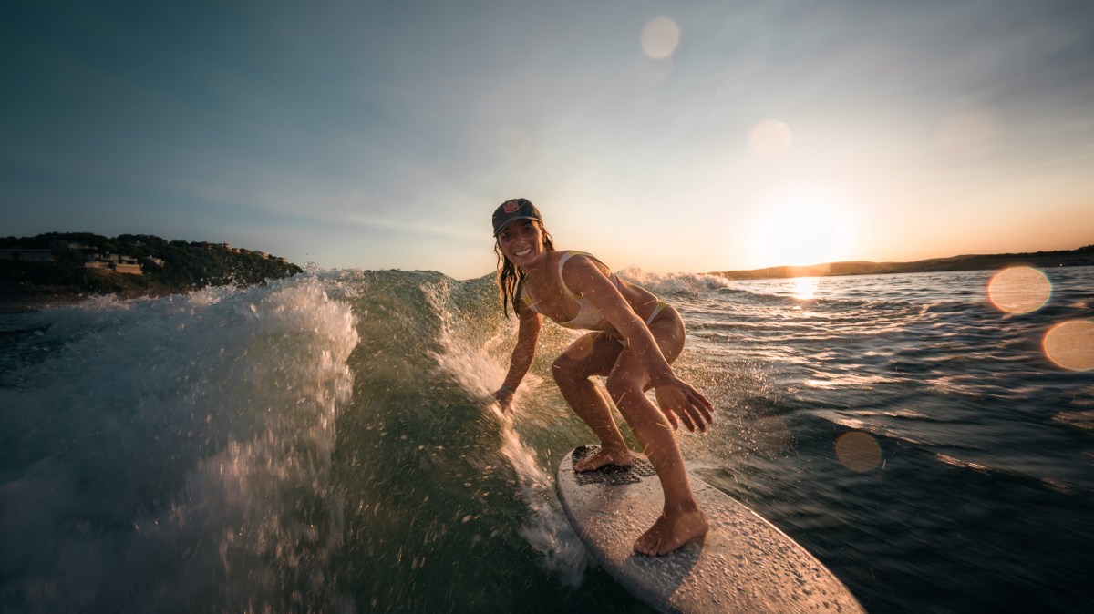 Capt Hannah from Centex Boat Rentals is riding a wave on a surfboard