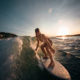 Capt Hanna riding a wave on a surfboard in the ocean