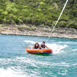 a man riding on the back of a boat in the water