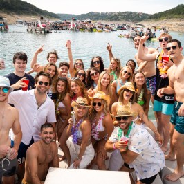 a group of people posing in front of a body of water